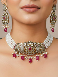 Close-up of a woman wearing an ornate traditional Ruby Red (Mehendi Polish)  Choker Diamond jewellery set and earrings with Pearls, Tumble Beads, American Diamond, Kundan and Ruby Red Colored Stones. Festive Diwali outfit styled with an American diamond artificial necklace. Close-up of high-quality  artificial American Diamond necklace craftsmanship.