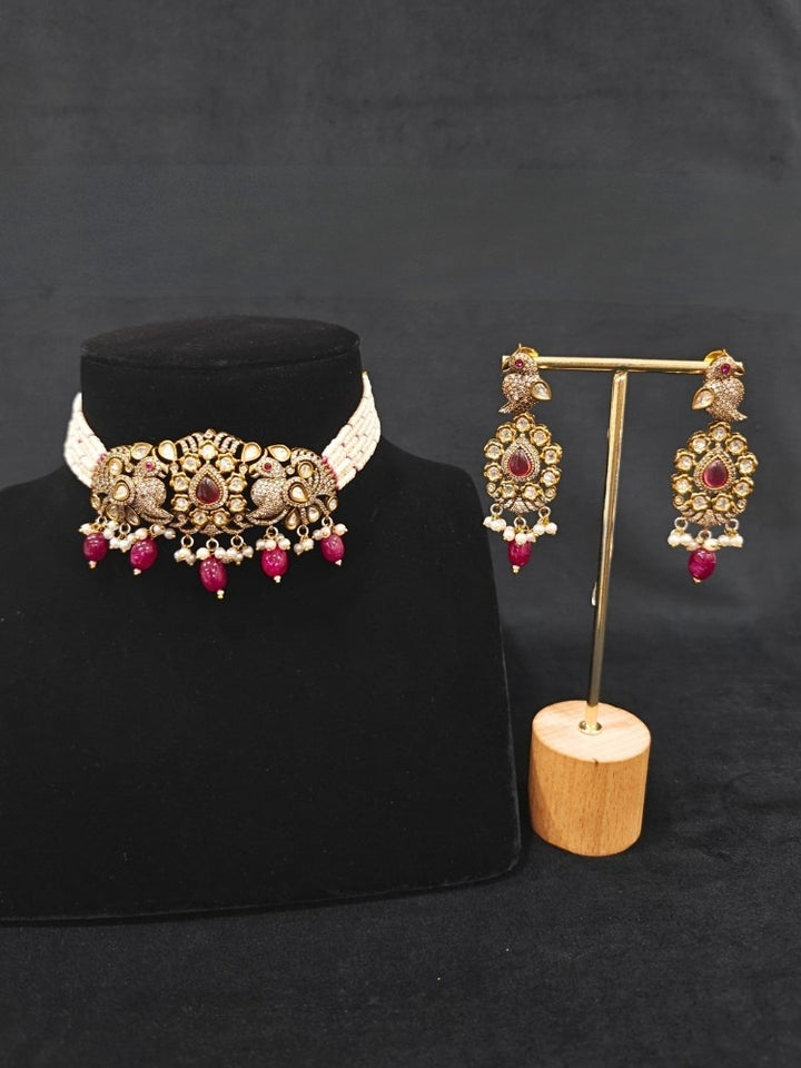 Close-up of an ornate traditional Ruby Red (Mehendi Polish)  Choker Diamond jewellery set and earrings with Pearls, Tumble Beads, American Diamond, Kundan and Ruby Red Colored Stones. Festive Diwali outfit styled with an American diamond artificial necklace. Close-up of high-quality  artificial American Diamond necklace craftsmanship.