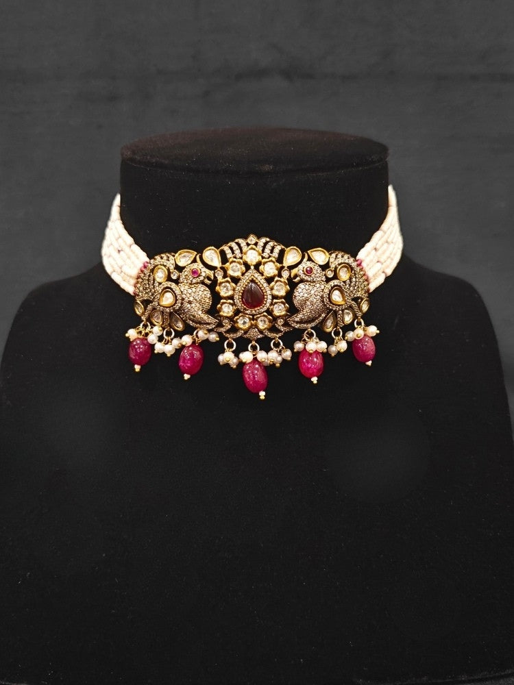 Close-up of an ornate traditional Ruby Red (Mehendi Polish)  Choker Diamond jewellery set and earrings with Pearls, Tumble Beads, American Diamond, Kundan and Ruby Red Colored Stones. Festive Diwali outfit styled with an American diamond artificial necklace. Close-up of high-quality  artificial American Diamond necklace craftsmanship.