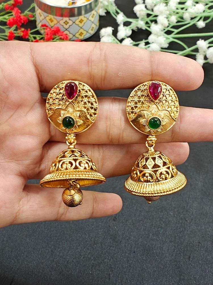 Close-up of an ornate traditional (Gold Polish) Earrings set with Colored Stone. Saree look completed with an elegant Colored Stone artificial jewelry piece. Woman wearing trending Colored Stone artificial jewelry for wedding season in India.