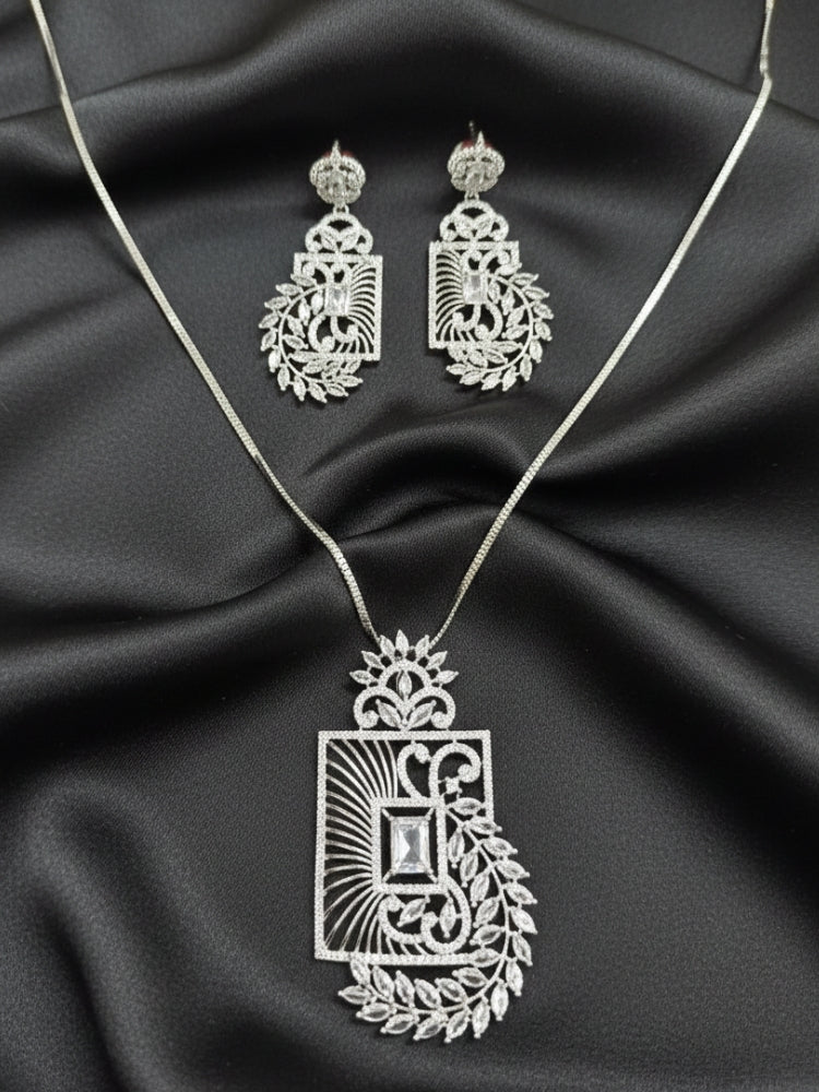 Close-up of an ornate Western (Silver Polish) Diamond Pendant set and earrings with American Diamonds. Elegant festive look with a high-quality imitation American diamond Pendant set. Close-up of a cocktail party look featuring a premium American diamond Pendant.