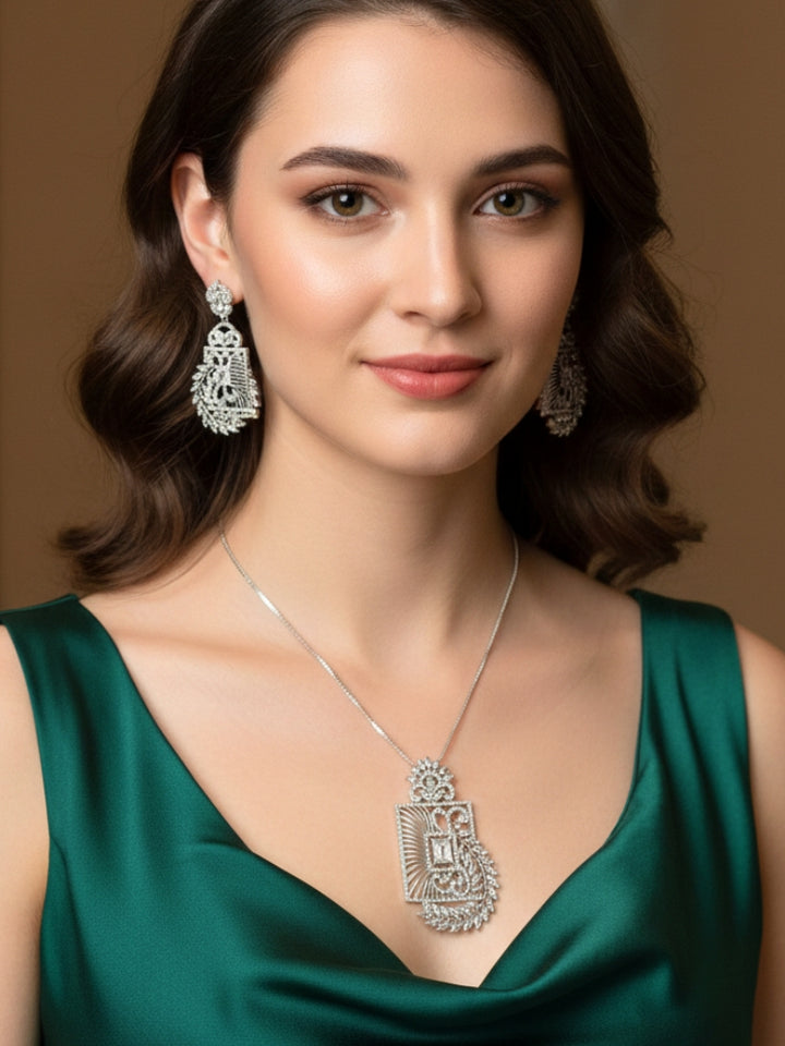 Close-up of a woman wearing an ornate Western (Silver Polish) Diamond Pendant set and earrings with American Diamonds. Elegant festive look with a high-quality imitation American diamond Pendant set. Close-up of a cocktail party look featuring a premium American diamond Pendant.