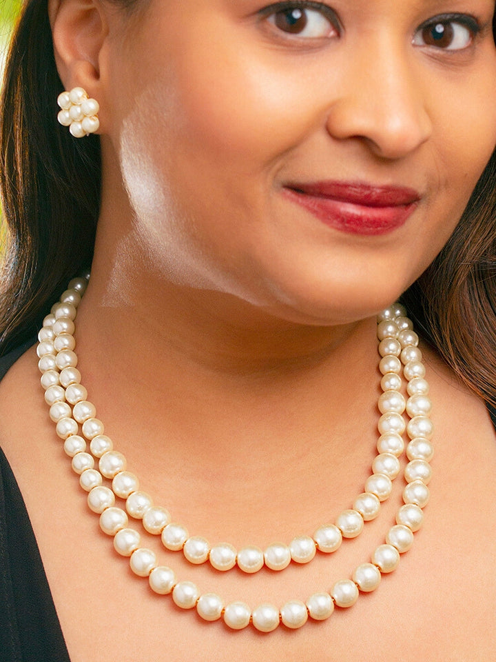 Close-up of a woman wearing an ornate Indo-Western White Pearl Layered Jewellery Set and Earring with Pearl. Indo-western outfit styled with a statement Pearl necklace set. Party wear outfit completed with a lightweight Pearl necklace.