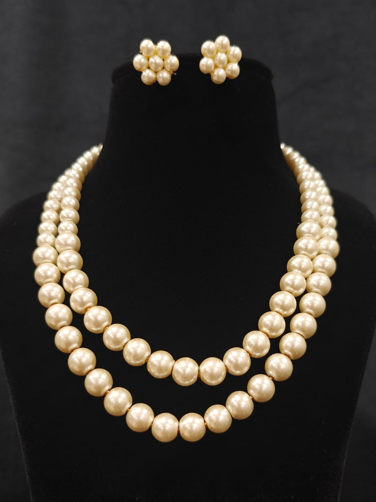 Close-up of an ornate Indo-Western White Pearl Layered Jewellery Set and Earring with Pearl. Indo-western outfit styled with a statement Pearl necklace set. Party wear outfit completed with a lightweight Pearl necklace.