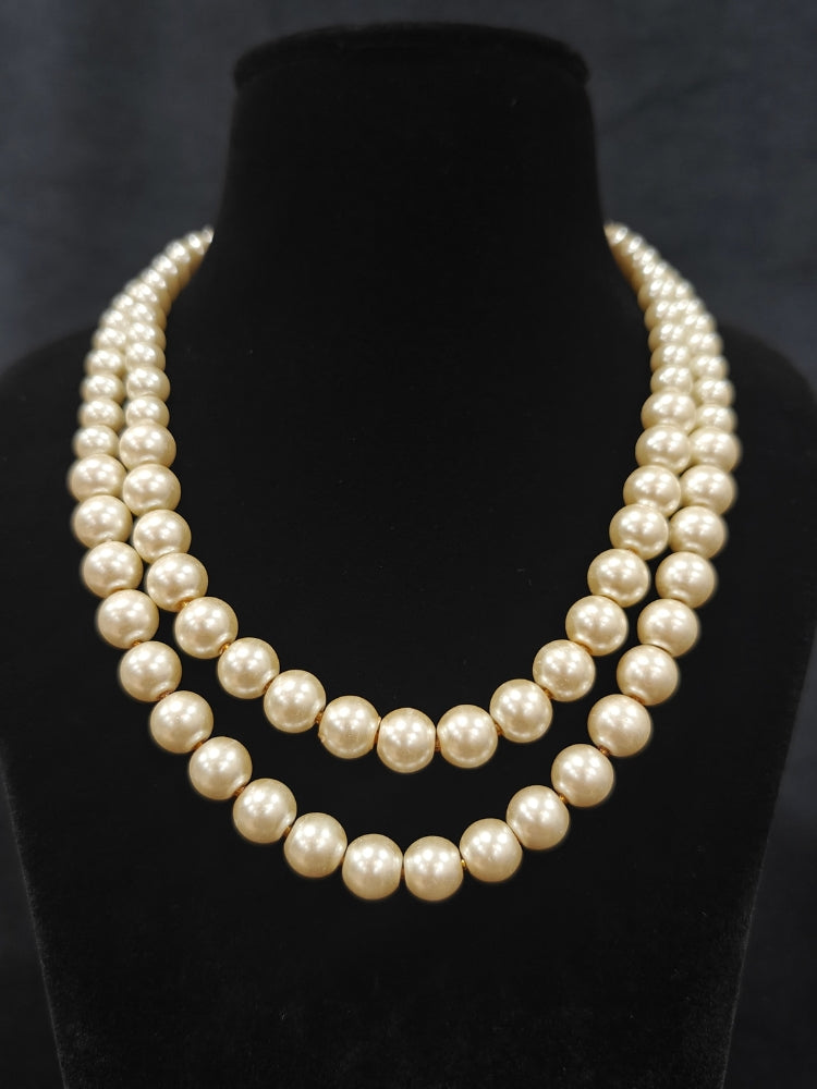 Close-up of an ornate Indo-Western White Pearl Layered Jewellery Set and Earring with Pearl. Indo-western outfit styled with a statement Pearl necklace set. Party wear outfit completed with a lightweight Pearl necklace.