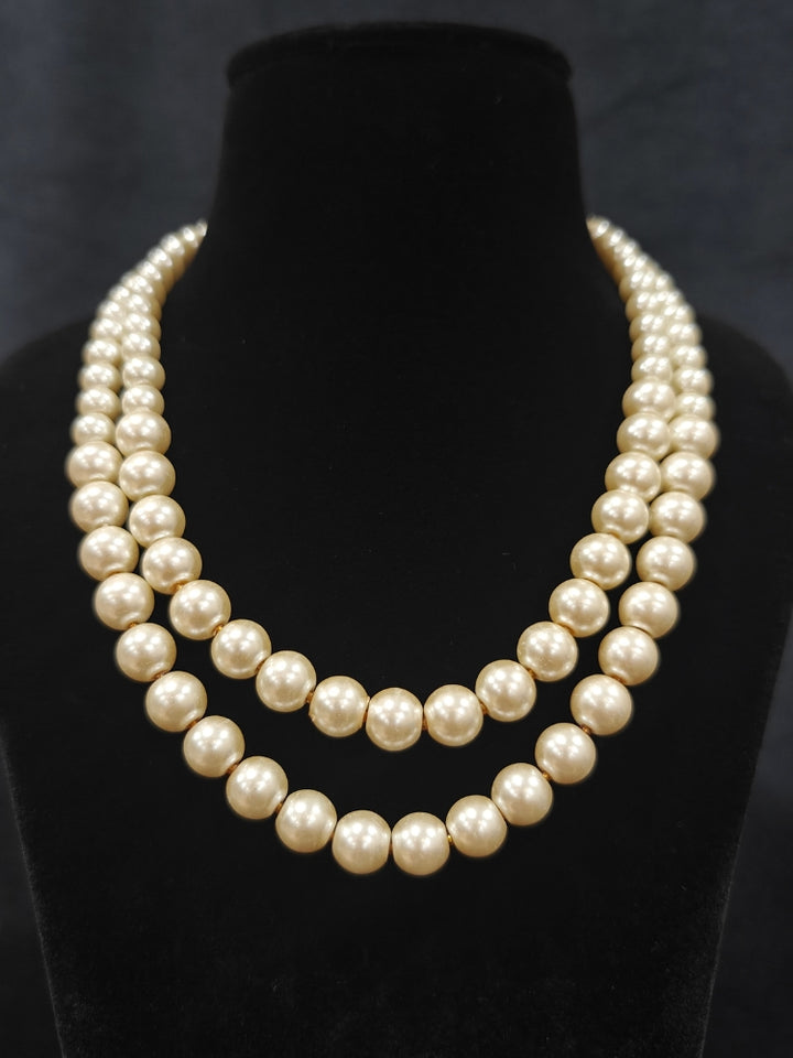 Close-up of an ornate Indo-Western White Pearl Layered Jewellery Set and Earring with Pearl. Indo-western outfit styled with a statement Pearl necklace set. Party wear outfit completed with a lightweight Pearl necklace.