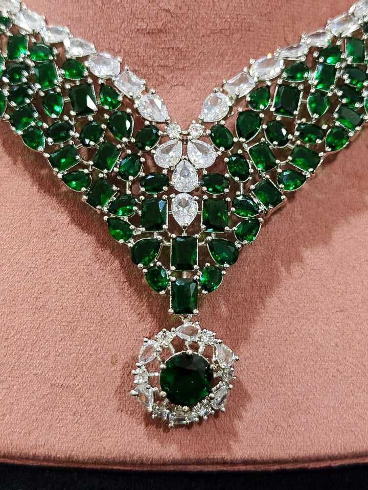 An exquisite artificial diamond necklace with green colored stone and matching earrings, designed for the perfect look. This stunning artificial diamond jewelry set offers luxury and sophistication while being an affordable alternative to natural diamonds.