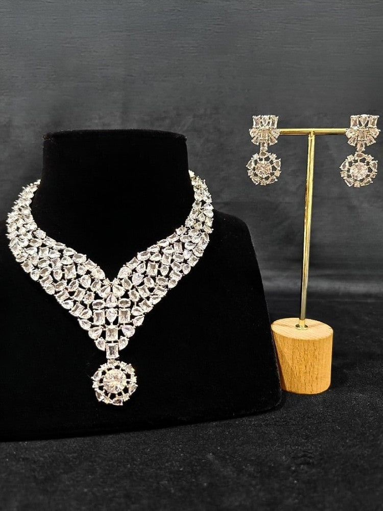 Close-up of an ornate Western American Diamond Silver Collar jewellery set and earrings with American Diamond. Elegant engagement jewelry look featuring a premium artificial American diamond necklace. Close-up of featuring an anti-tarnish American diamond artificial necklace.