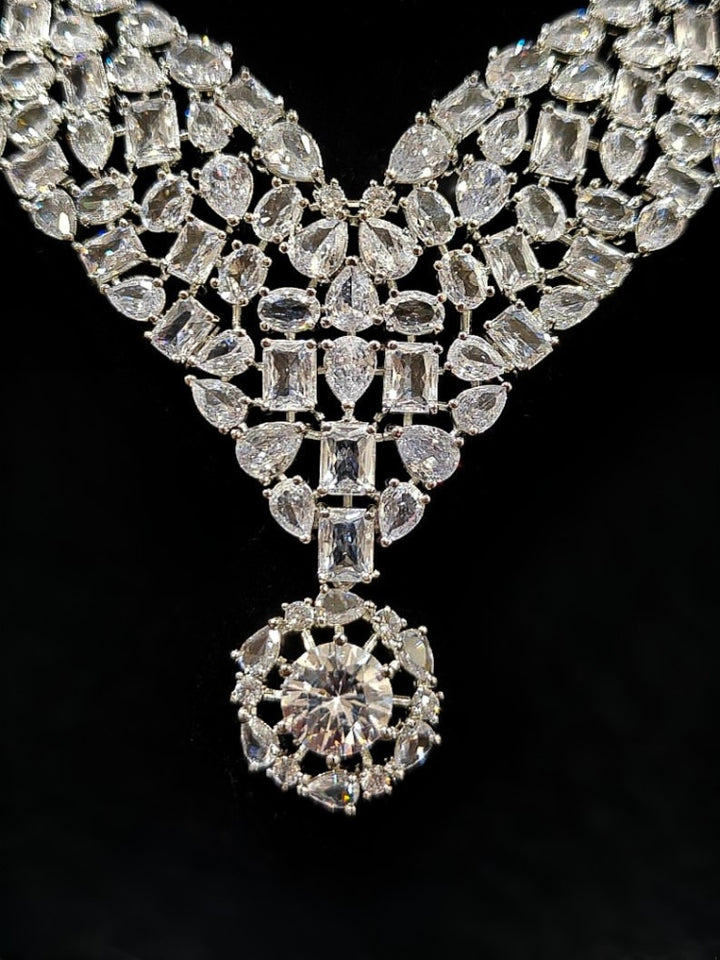 Close-up of an ornate Western American Diamond Silver Collar jewellery set and earrings with American Diamond. Elegant engagement jewelry look featuring a premium artificial American diamond necklace. Close-up of featuring an anti-tarnish American diamond artificial necklace.