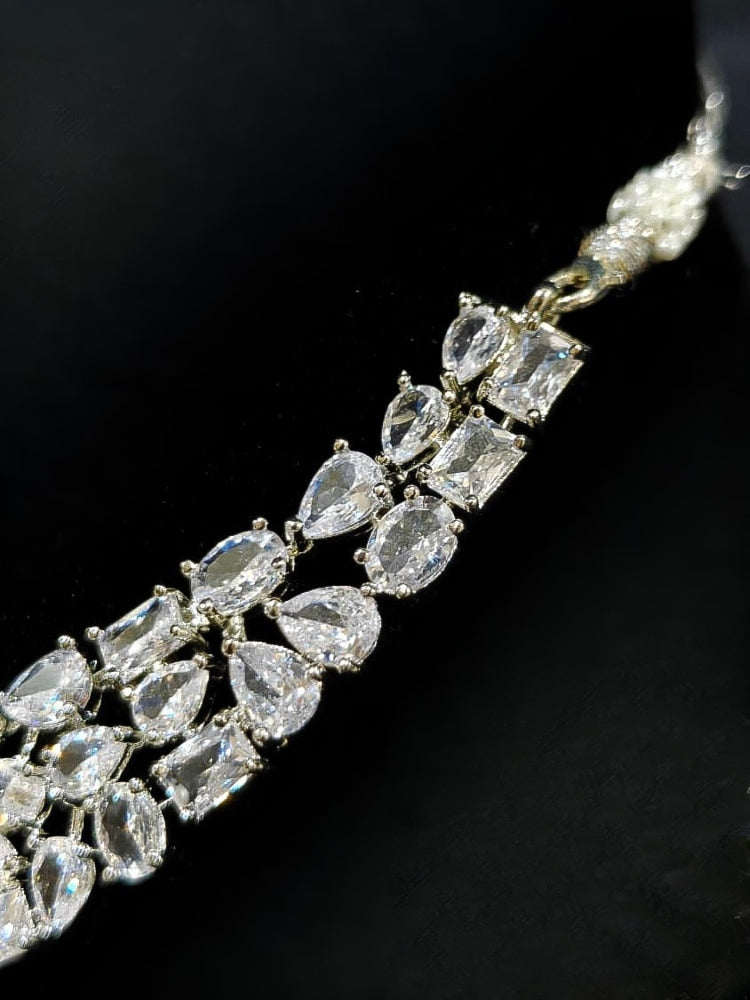 Close-up of an ornate Western American Diamond Silver Collar jewellery set and earrings with American Diamond. Elegant engagement jewelry look featuring a premium artificial American diamond necklace. Close-up of featuring an anti-tarnish American diamond artificial necklace.