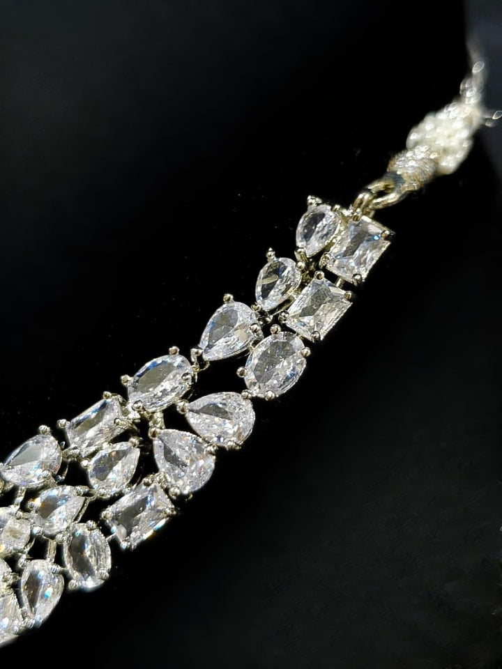 Close-up of an ornate Western American Diamond Silver Collar jewellery set and earrings with American Diamond. Elegant engagement jewelry look featuring a premium artificial American diamond necklace. Close-up of featuring an anti-tarnish American diamond artificial necklace.