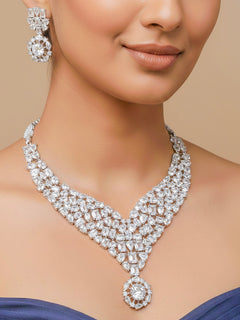 Close-up of a woman wearing an ornate Western American Diamond Silver Collar jewellery set and earrings with American Diamond. Elegant engagement jewelry look featuring a premium artificial American diamond necklace. Woman styling a statement American diamond necklace with an off-shoulder gown for a reception.
