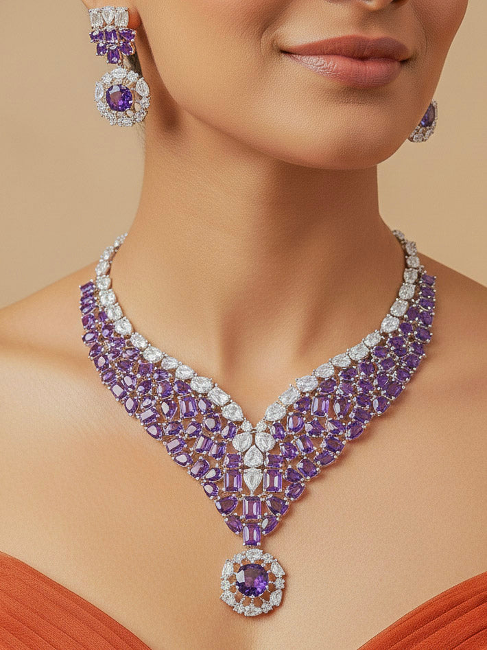 Close-up of a woman wearing an ornate Western Purple Colored Stone Silver Collar jewellery set and earrings with American Diamond and Colored Stones. Woman styling a statement Colored Stones necklace with an off-shoulder gown for a reception and Party.