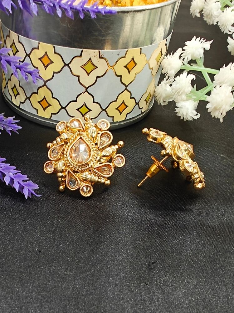Eliza Earrings showcase intricate floral designs with reverse American diamond accents, displayed on Black Surface with White and a Purple flower in the background.
