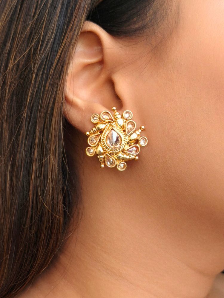 A women Wearing Eliza Earrings showcase intricate floral designs with reverse American diamond accents. Close-up of anti-tarnish artificial Studs earrings for festive celebrations. Indo-western dress styled with lightweight artificial Studs Earrings.