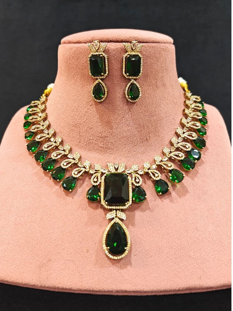 A stunning affordable artificial diamond and emerald green colored stone necklace and matching earrings set, perfect for wedding guests and formal events. This luxury artificial diamond jewelry provides the brilliance of real diamonds at a fraction of the cost. Festive Diwali outfit styled with an American diamond artificial necklace.