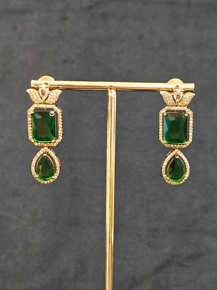 A stunning affordable artificial diamond and emerald green colored stone necklace and matching earrings set, perfect for wedding guests and formal events. This luxury artificial diamond jewelry provides the brilliance of real diamonds at a fraction of the cost. Festive Diwali outfit styled with an American diamond artificial necklace.