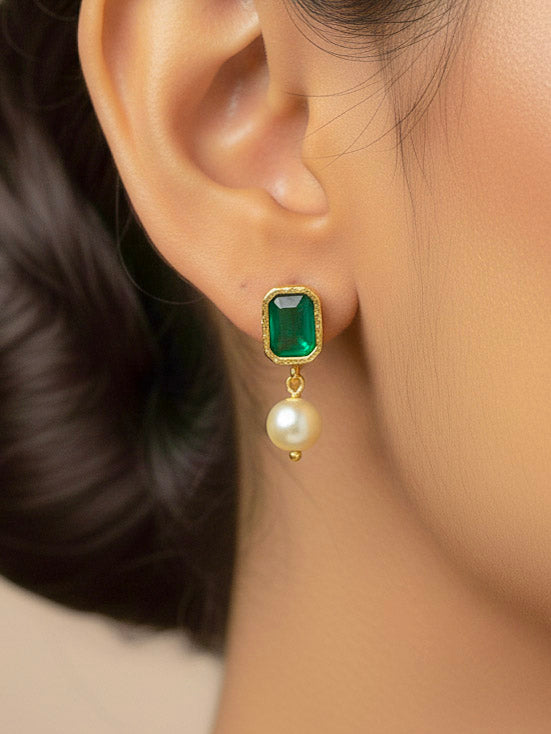 Close-up of a woman wearing an ornate traditional (Gold Polish) Emerald Green Choker jewellery set and earrings with Colored Stones, Pearl and American Diamonds. Festive Diwali outfit styled with an Colored Stones artificial necklace. Mehendi function outfit styled with a Colored Stone  necklace set.
