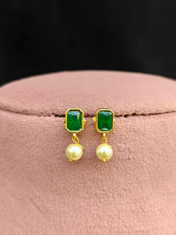 Close-up of an ornate traditional (Gold Polish) Emerald Green Choker jewellery set and earrings with Colored Stones, Pearl and American Diamonds. Festive Diwali outfit styled with an Colored Stones artificial necklace. Mehendi function outfit styled with a Colored Stone  necklace set.