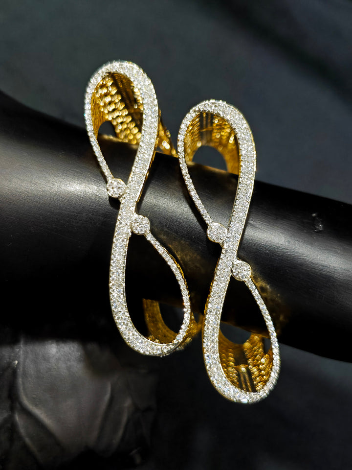 Close-up of an ornate Indo-western Diamond Gold Bangles with American Diamond, Filigree Work and Infinity Design. Wedding guest look completed with lightweight American Diamond artificial bangles. Perfect American Diamond necklace set for weddings and festivals.