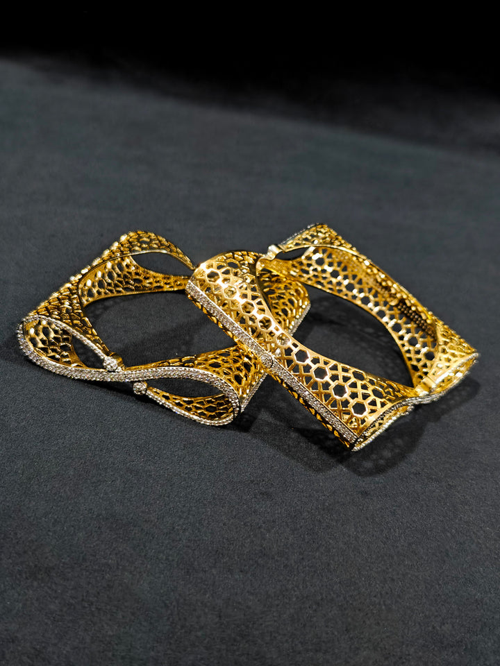 Close-up of an ornate Indo-western Diamond Gold Bangles with American Diamond, Filigree Work and Infinity Design. Wedding guest look completed with lightweight American Diamond artificial bangles. Perfect American Diamond necklace set for weddings and festivals.