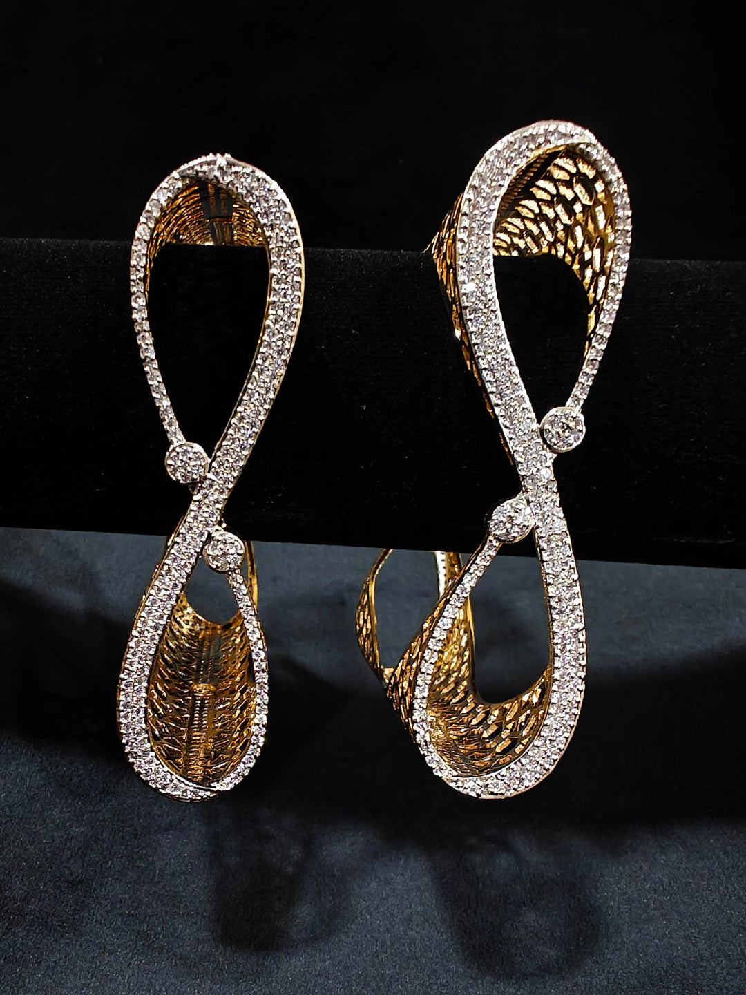 Close-up of an ornate Indo-western Diamond Gold Bangles with American Diamond, Filigree Work and Infinity Design. Wedding guest look completed with lightweight American Diamond artificial bangles. Perfect American Diamond necklace set for weddings and festivals.