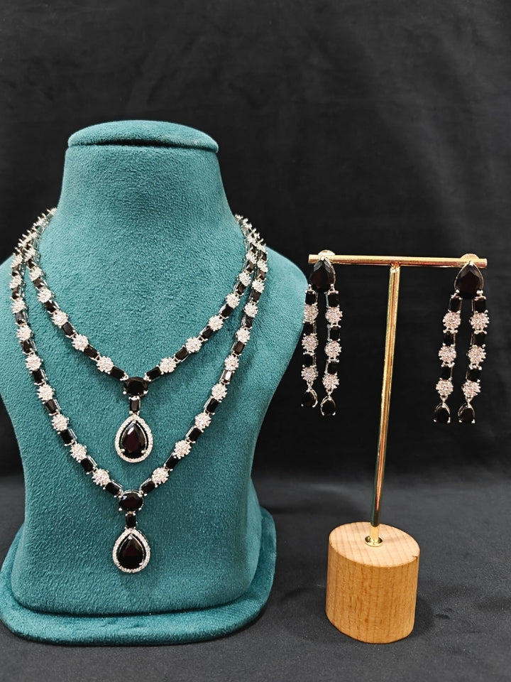 "Close-up of a woman wearing a sparkling artificial diamond and black colored stone Layered necklace and diamond earrings set, designed to offer a radiant, elegant look for any formal occasion or Indian wedding. This affordable diamond jewelry provides a flawless, luxurious alternative to natural diamonds."
