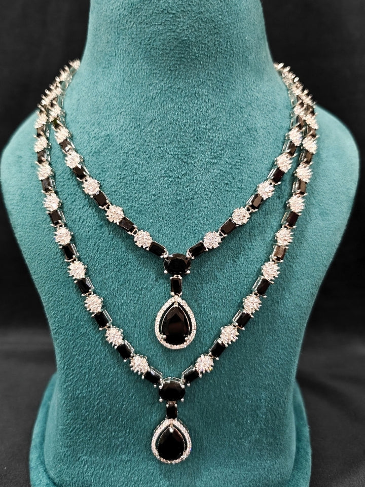 "Close-up of a woman wearing a sparkling artificial diamond and black colored stone Layered necklace and diamond earrings set, designed to offer a radiant, elegant look for any formal occasion or Indian wedding. This affordable diamond jewelry provides a flawless, luxurious alternative to natural diamonds."
