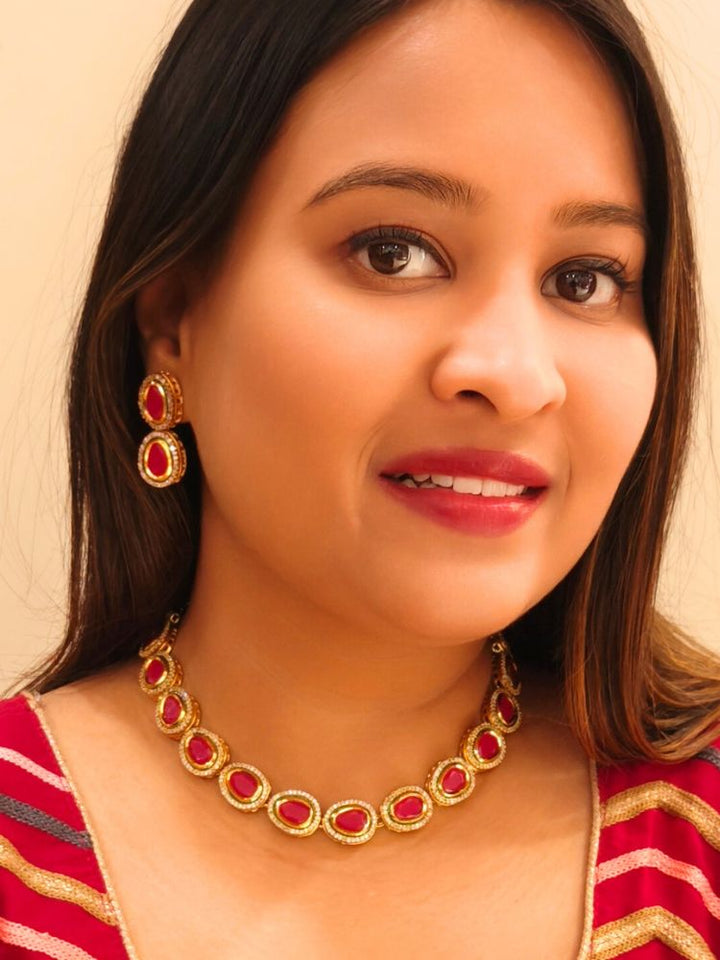 Close-up of a woman wearing an ornate traditional (Gold Polish) Pink Collar jewellery set and earrings with American Diamond and Pink Colored Stone. Festive Diwali outfit paired with a colorful Colored Stone necklace. Festive celebration look enhanced with traditional Colored Stone jewelry.