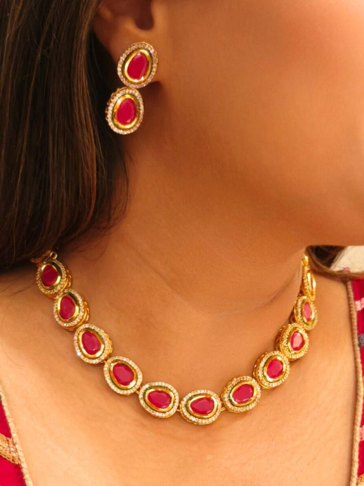 Close-up of a woman wearing an ornate traditional (Gold Polish) Pink Collar jewellery set and earrings with American Diamond and Pink Colored Stone. Festive Diwali outfit paired with a colorful Colored Stone necklace. Festive celebration look enhanced with traditional Colored Stone jewelry.
