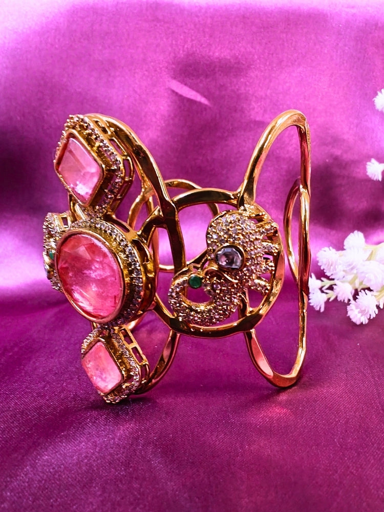 The Farah Mint Pink Bracelet (Adjustable) features intricate designs, three bold Mint Pink gemstones, and two elephant heads adorned with American diamonds —ideal for wedding ceremonies—shown on a purple fabric background.