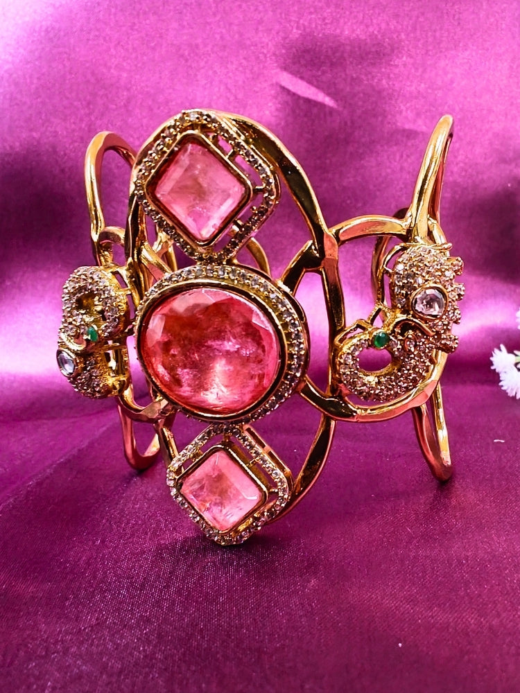 The Farah Mint Pink Bracelet (Adjustable) features intricate designs, three bold Mint Pink gemstones, and two elephant heads adorned with American diamonds —ideal for wedding ceremonies—shown on a purple fabric background.