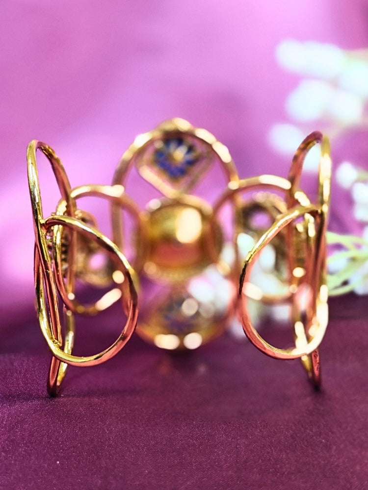 The Farah Navy Blue Bracelet (Adjustable) features intricate designs, three bold Navy Blue gemstones, and two elephant heads adorned with American diamonds —ideal for wedding ceremonies—shown on a purple fabric background.