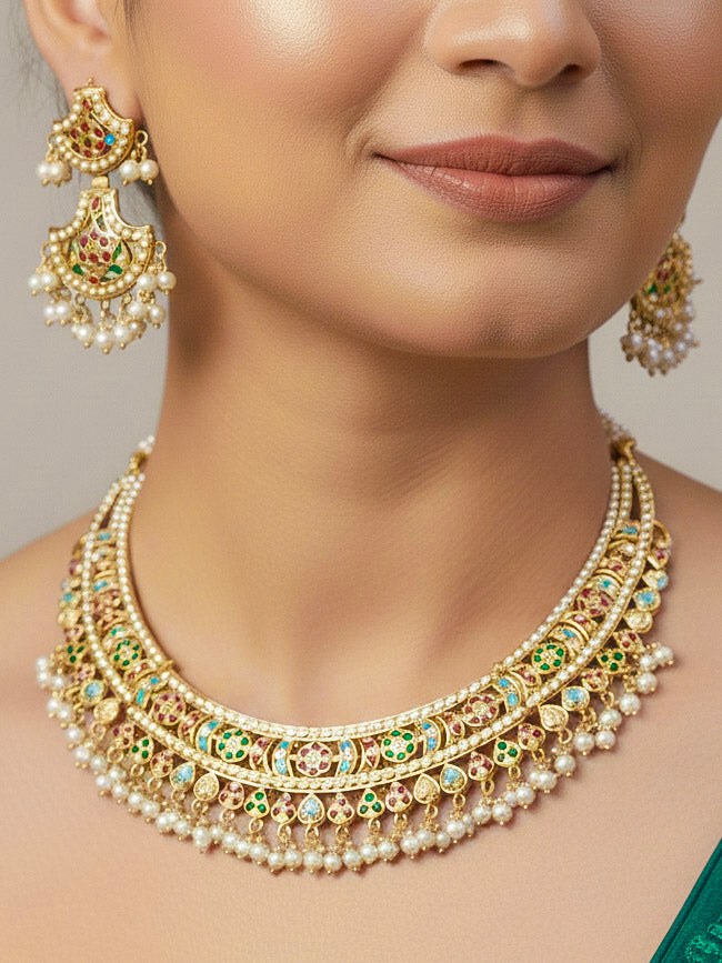Close-up of a woman wearing a gold Indian traditional jadau jewellery with pearls and multicolor jadau stones, and matching jadau earrings. This authentic jadau jewelry set can we worn as jadau necklace set for weddings. 