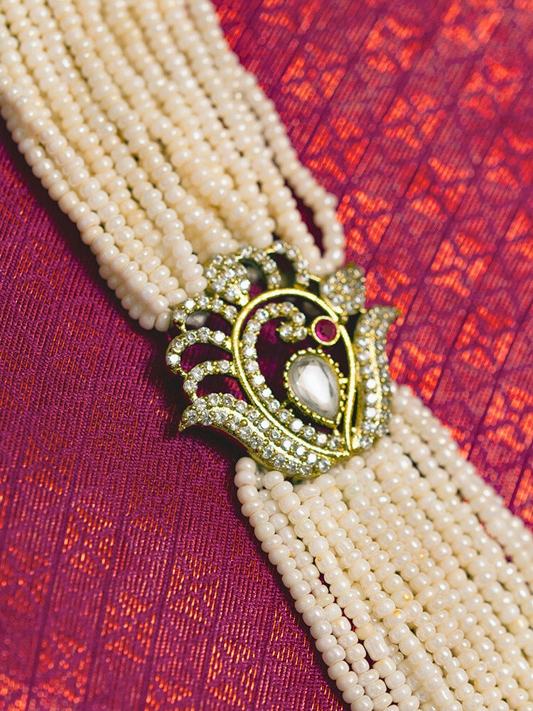 Close-up of a woman wearing an ornate traditional White Rajwadi gold Long Necklace with Pearls, American Diamond, Kundan. Festive Diwali outfit enhanced with a Rajwadi artificial necklace. Festive look completed with a luxury Rajwadi imitation necklace.