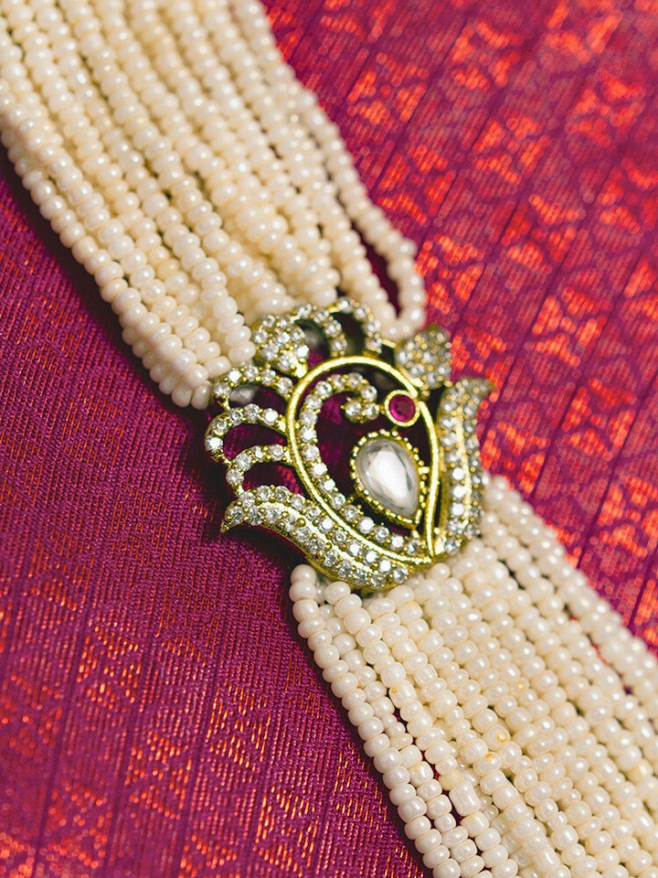 Close-up of a woman wearing an ornate traditional White Rajwadi gold Long Necklace with Pearls, American Diamond, Kundan. Festive Diwali outfit enhanced with a Rajwadi artificial necklace. Festive look completed with a luxury Rajwadi imitation necklace.