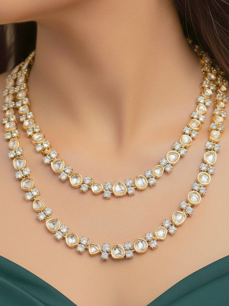 Close-up of a woman wearing an ornate Indo-western Layered Kundan (gold Polish) jewellery set and earrings with American Diamond and Kundan. Indo-western outfit styled with a lightweight Kundan necklace. Reception-ready look featuring elegant Kundan imitation jewelry.