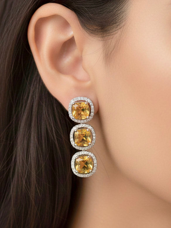 "A stunning woman wearing a glamorous artificial diamond necklace with yellow colored stone paired with chic earrings and maangtikka, perfect for bridal wear. This high-quality artificial diamond jewelry set is the ideal choice for modern brides looking for a budget-friendly option with timeless sparkle."
