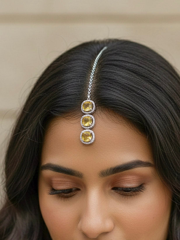"Close-up of a model in luxurious artificial diamond jewelry featuring a designer diamond necklace with yellow colored stone and earrings and maangtikka set, crafted for bridal fashion and high-end weddings. This beautiful diamond jewelry set offers the brilliance of real diamonds at an affordable price."
