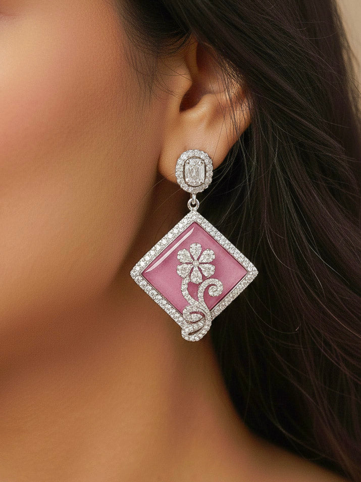 Close-up of a woman wearing an ornate Western Pink (Silver Polish) Colored Pendant set and earrings with American Diamond and Colored Stones. Festive Diwali outfit styled with an American diamond artificial necklace. Reception-ready look featuring a statement American diamond jewelry set.