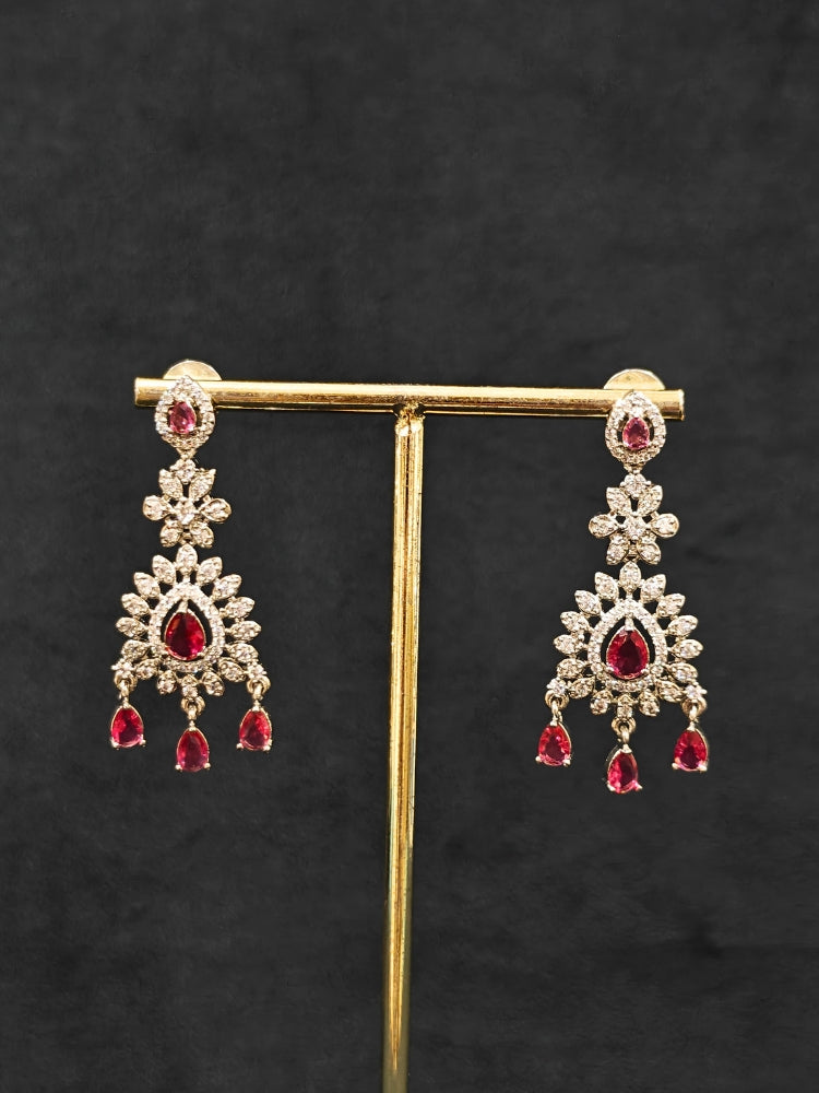 Close-up of an ornate Indo-Western Red American Diamond Silver Collar Layered jewellery set and earrings with American Diamond and Colored Stones. Bride-to-be styled in a premium American diamond artificial necklace for her reception party. Close-up of a bridal look featuring an anti-tarnish American diamond artificial necklace.