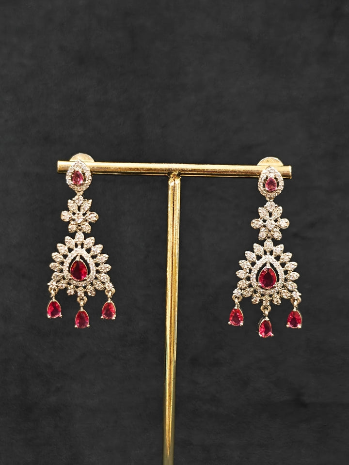 Close-up of an ornate Indo-Western Red American Diamond Silver Collar Layered jewellery set and earrings with American Diamond and Colored Stones. Bride-to-be styled in a premium American diamond artificial necklace for her reception party. Close-up of a bridal look featuring an anti-tarnish American diamond artificial necklace.