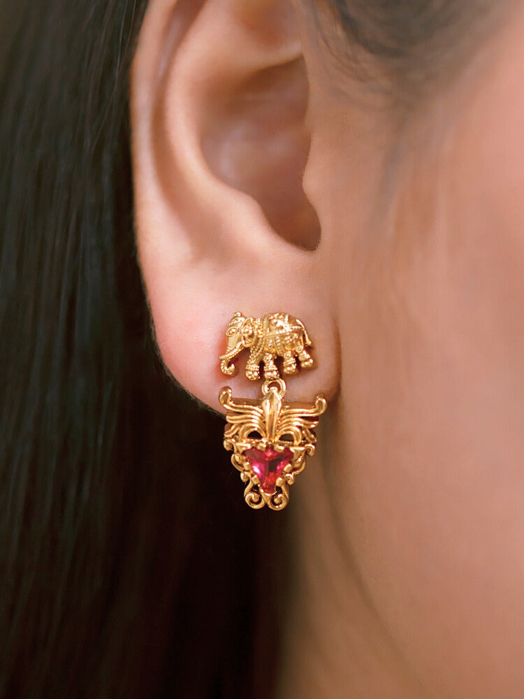 A woman smiles in a green and red saree, adorned with the Gajvani Red & White Necklace Set—gold necklace and earrings featuring intricate elephant designs with red & White colored stones. Great simple elegant temple jewelry necklace set for festive occasions 