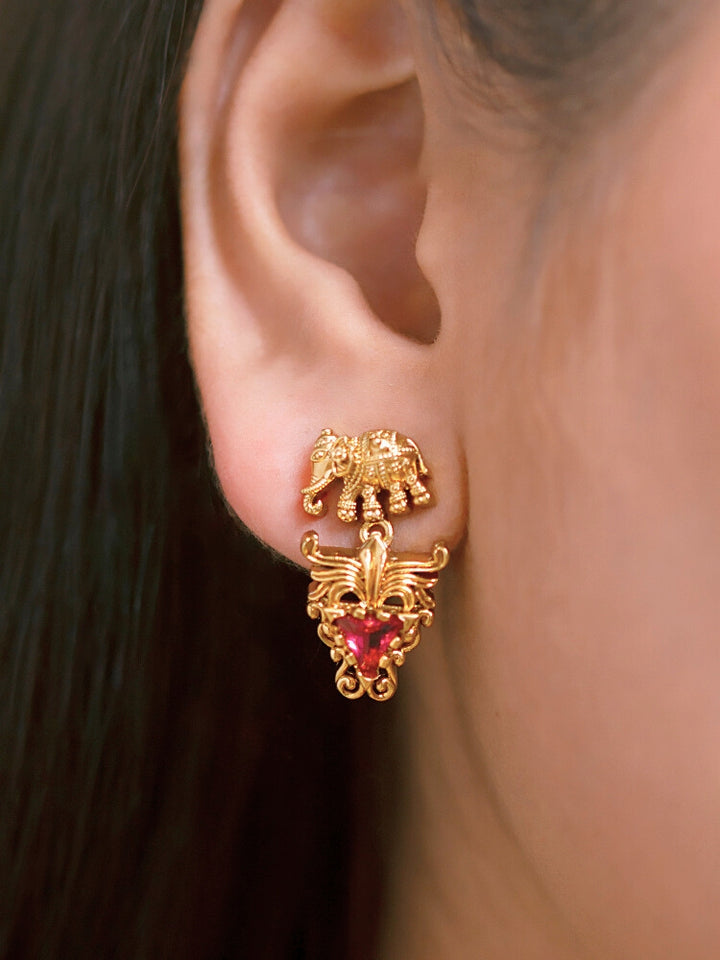 A woman smiles in a green and red saree, adorned with the Gajvani Red & White Necklace Set—gold necklace and earrings featuring intricate elephant designs with red & White colored stones. Great simple elegant temple jewelry necklace set for festive occasions 