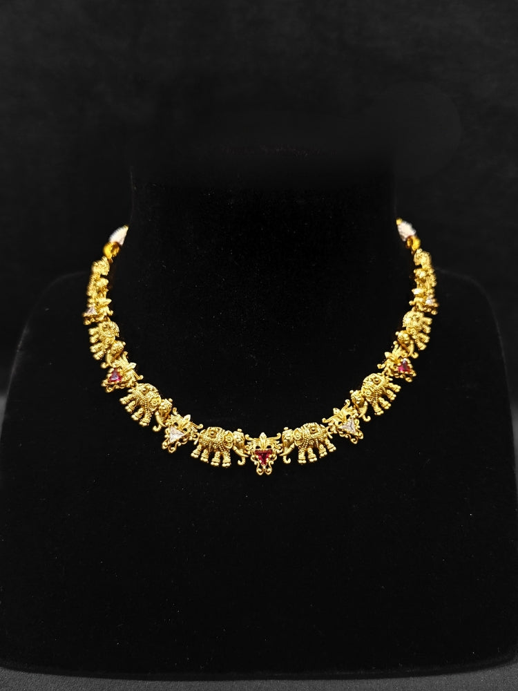 The Gajvani Red & White Necklace Set featuring a traditional gold collar necklace and matching earrings along with Red & White colored stones, golden elephants, ideal party jewelry for any festive occasion. Festive Diwali look completed with a traditional temple necklace set.