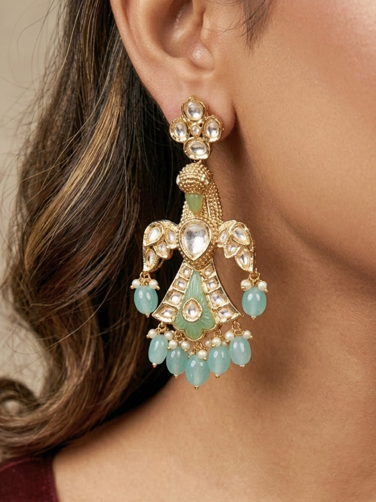 Close-up of a woman wearing an ornate traditional (Gold Polish) Sea Green Long jewellery set and earrings with Polki and Tumble Beads. Festive celebration look completed with premium imitation Polki jewelry. Woman wearing trending Polki artificial jewelry for the wedding season in India.