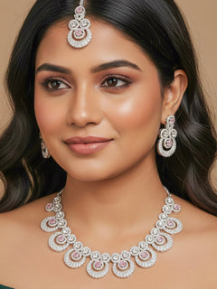 Close-up of a woman wearing an ornate Western Mint Pink Diamond SIlver Collar jewellery set and earrings and maangtikka with American Diamond and Mint Pink Colored Stones. Bride-to-be styled in a premium American diamond artificial necklace for her reception party. Close-up of a bridal look featuring an anti-tarnish American diamond artificial necklace.