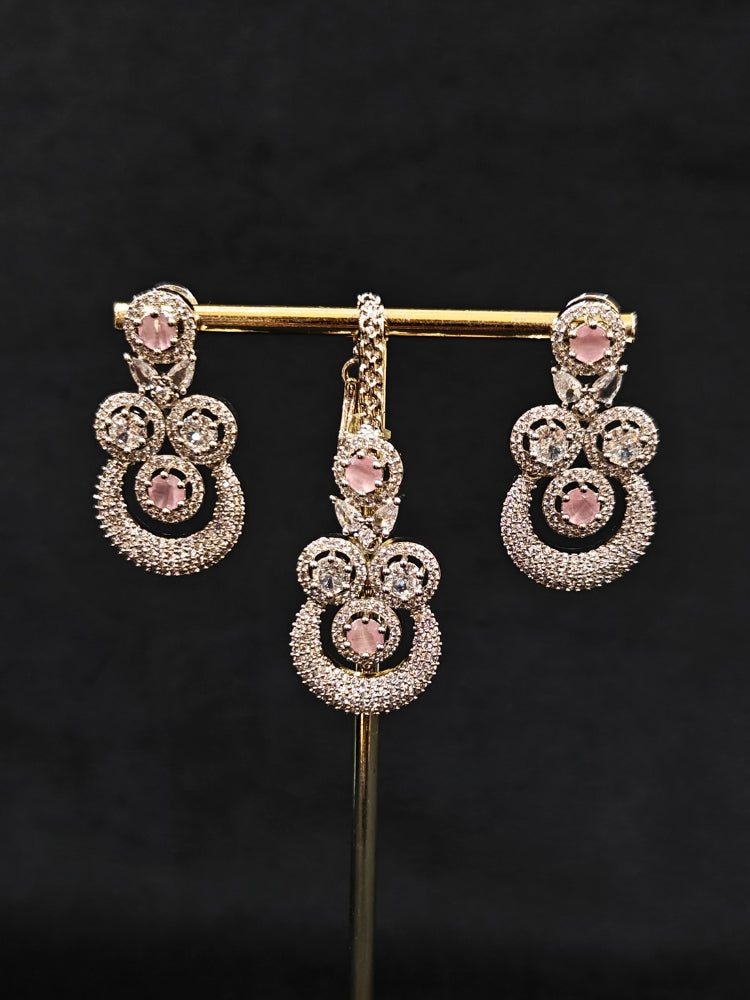 Close-up of an ornate Western Mint Pink Diamond SIlver Collar jewellery set and earrings and maangtikka with American Diamond and Mint Pink Colored Stones. A premium American diamond artificial necklace for her reception party. Close-up of a bridal look featuring an anti-tarnish American diamond artificial necklace.
