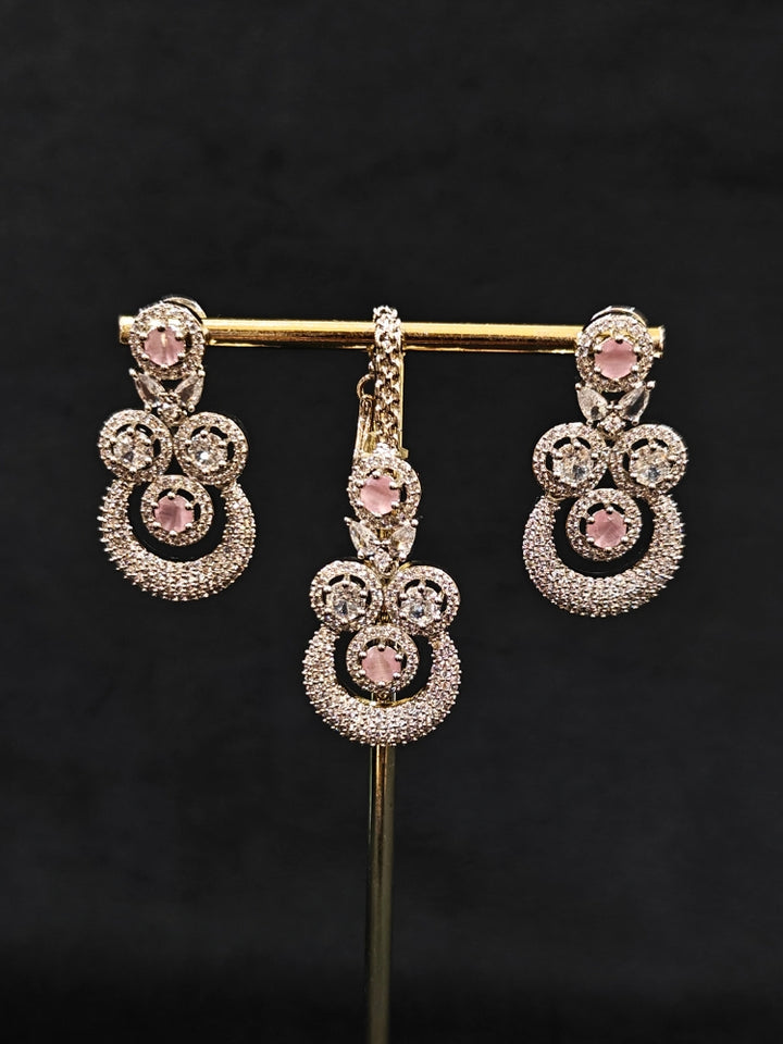 Close-up of an ornate Western Mint Pink Diamond SIlver Collar jewellery set and earrings and maangtikka with American Diamond and Mint Pink Colored Stones. A premium American diamond artificial necklace for her reception party. Close-up of a bridal look featuring an anti-tarnish American diamond artificial necklace.