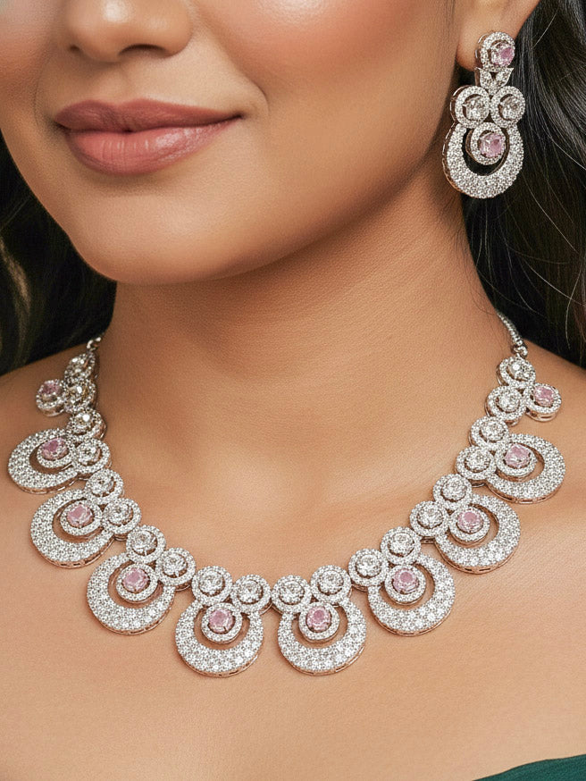 Close-up of a woman wearing an ornate Western Mint Pink Diamond SIlver Collar jewellery set and earrings and maangtikka with American Diamond and Mint Pink Colored Stones. Bride-to-be styled in a premium American diamond artificial necklace for her reception party. Close-up of a bridal look featuring an anti-tarnish American diamond artificial necklace.